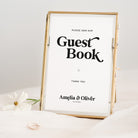 Gold-framed sign that reads 'Please sign our Guest Book' with personalized names and date.
