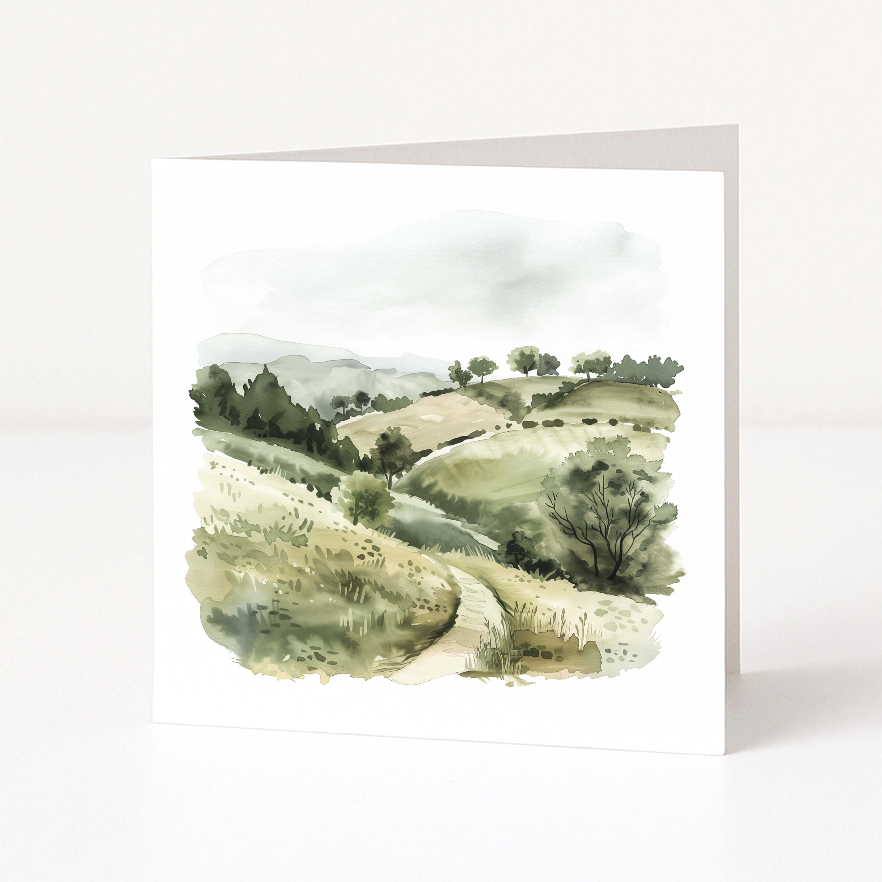 Greeting card with a watercolor landscape of rolling hills and trees on a white background