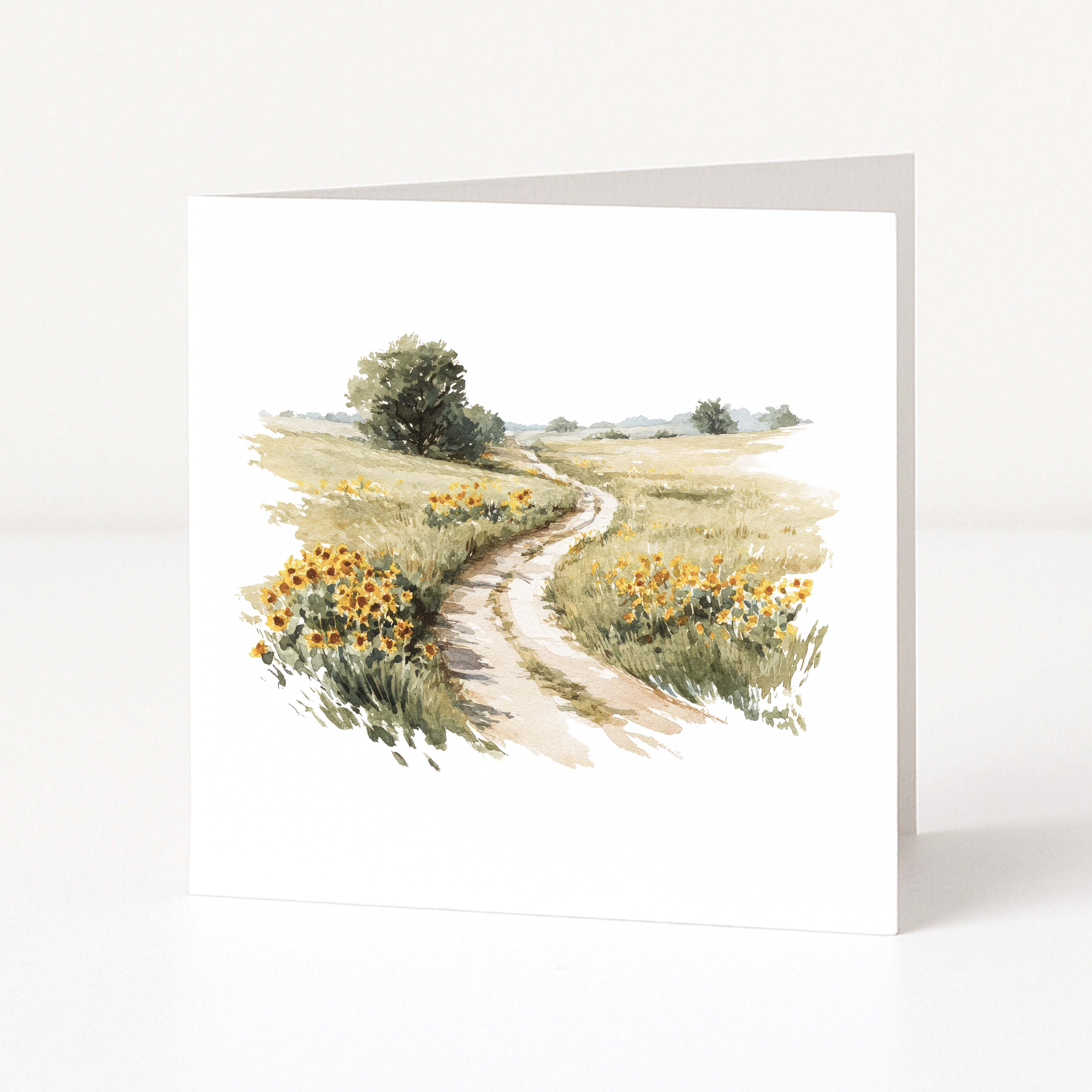 Greeting card with a watercolor illustration of a winding path through a field of sunflowers on a white background.