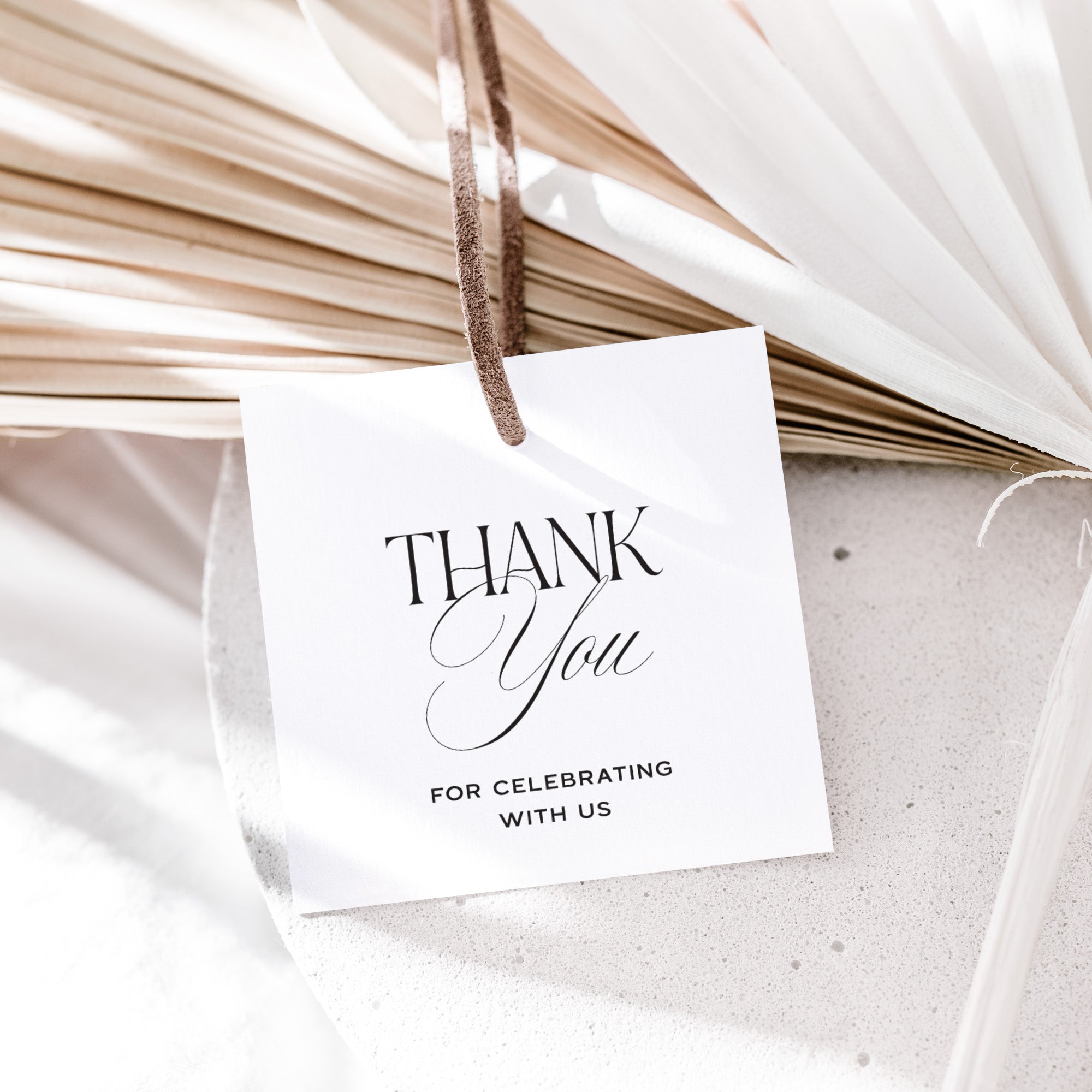 White card with 'Thank You for Celebrating with Us' text hanging on dried plants.