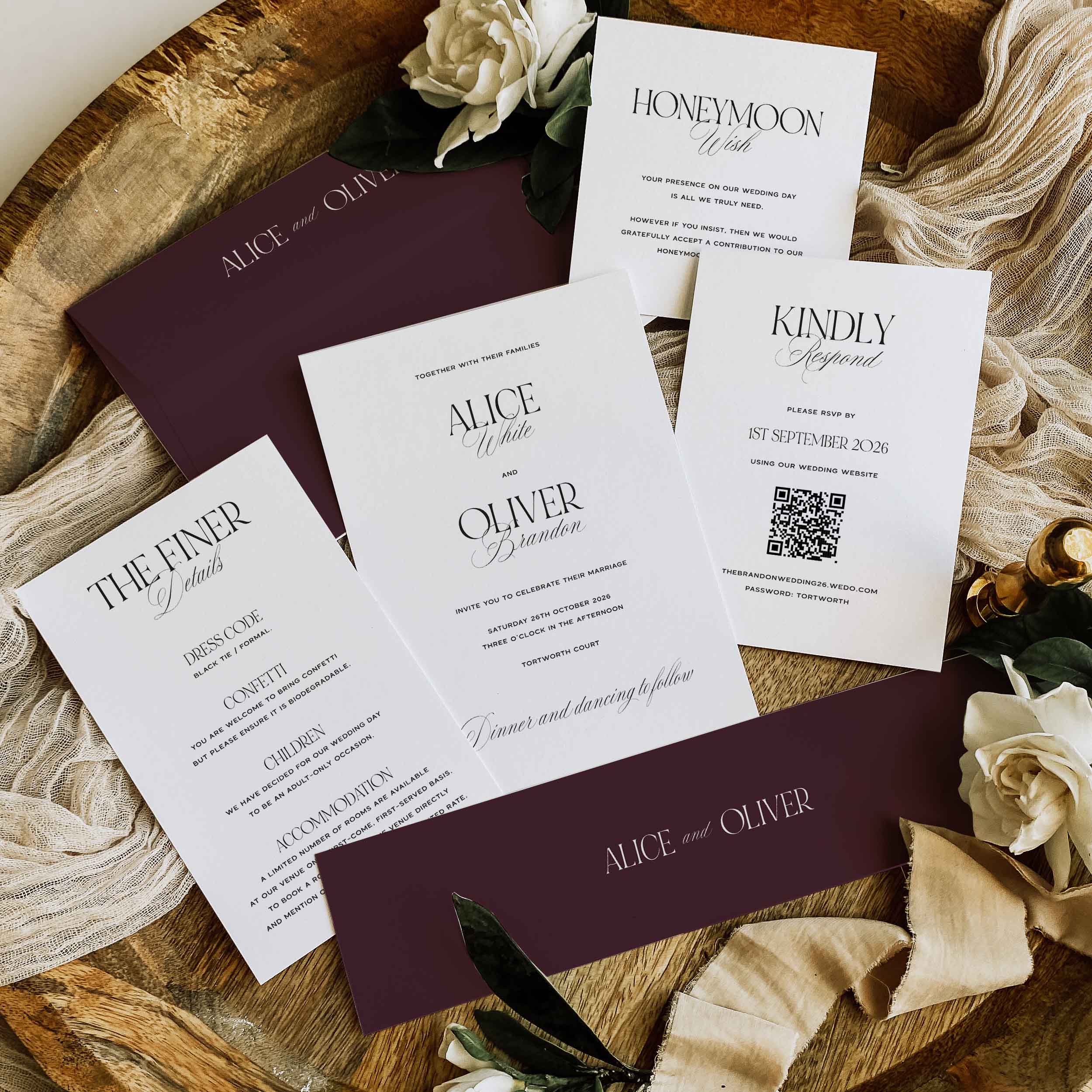 Wedding invitation set with floral decorations on a wooden surface