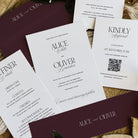 Wedding invitation cards with details and a QR code on a wooden surface.