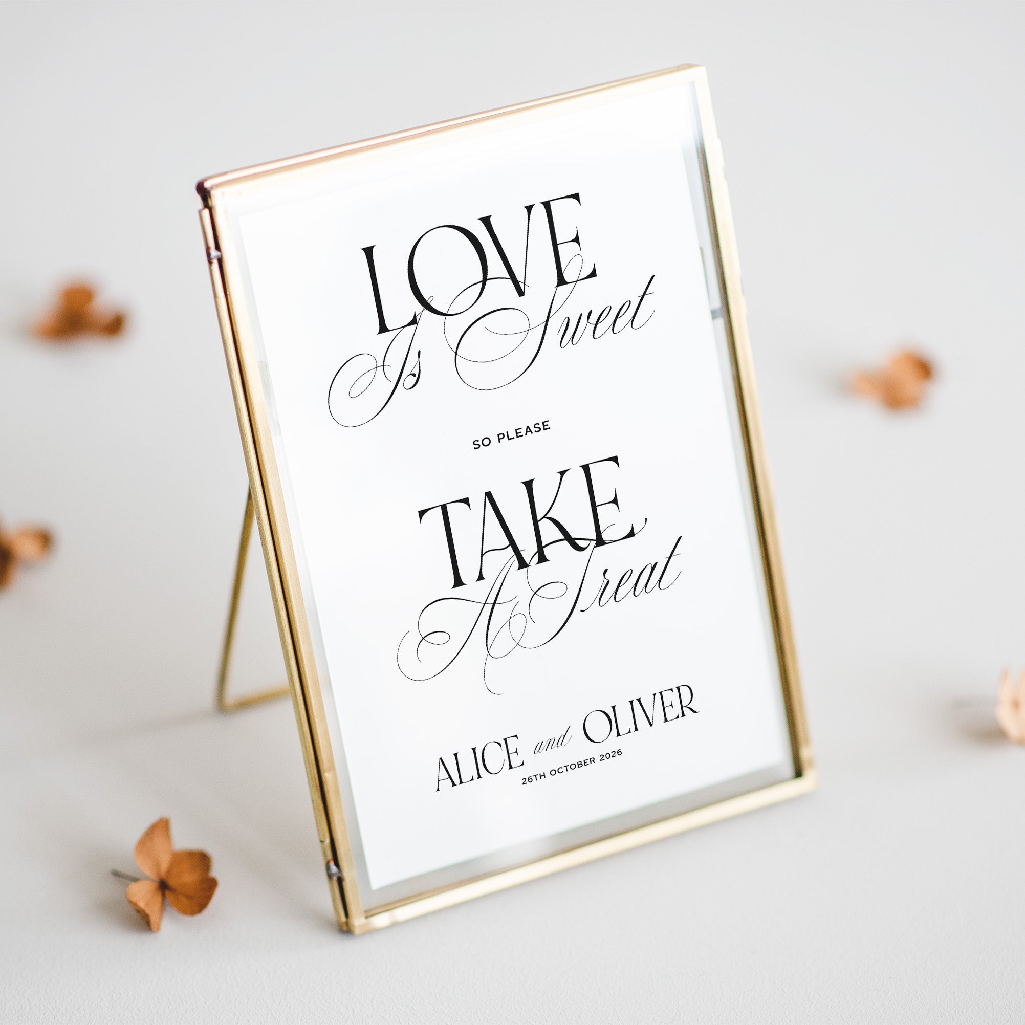 Decorative sign with 'Love is Sweet Take A Treat' text in a gold frame on a light background