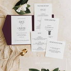 Wedding invitation set with envelope, RSVP card, and menu on a marble surface.