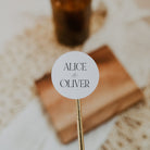 Round label with 'Alice & Oliver' text on a stick, blurred background