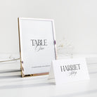 Wedding Table number and place card on a white surface with a gold frame