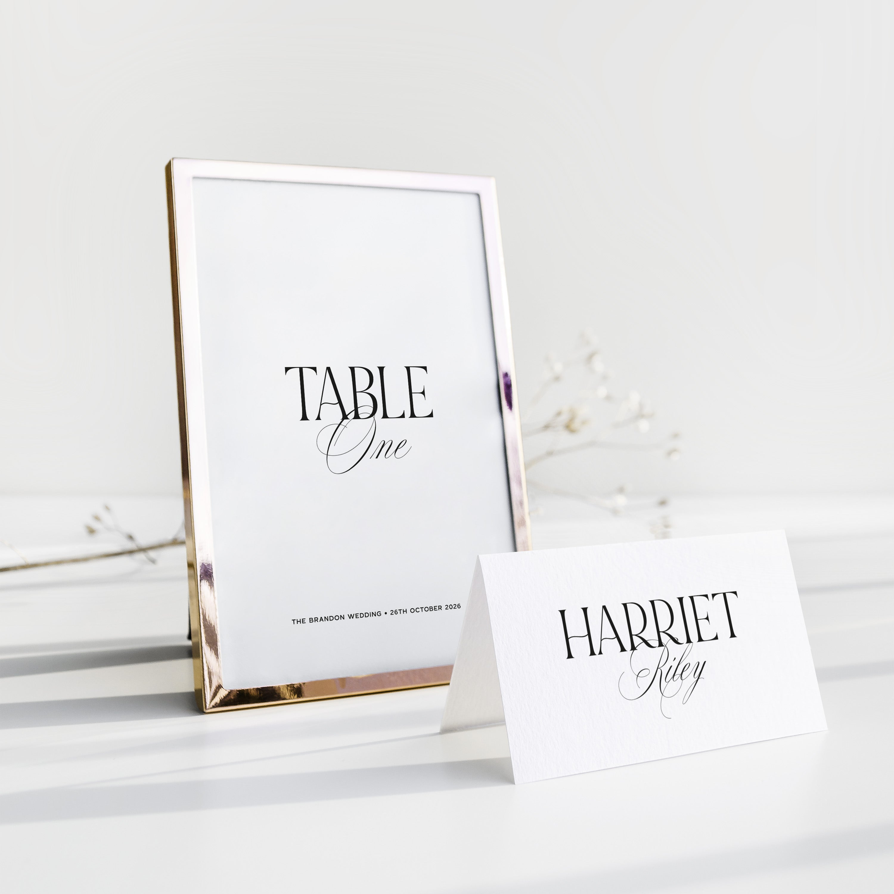 Wedding Table number and place card on a white surface with a gold frame