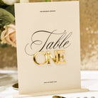 Table number card for 'Table One' with gold text on a decorative background