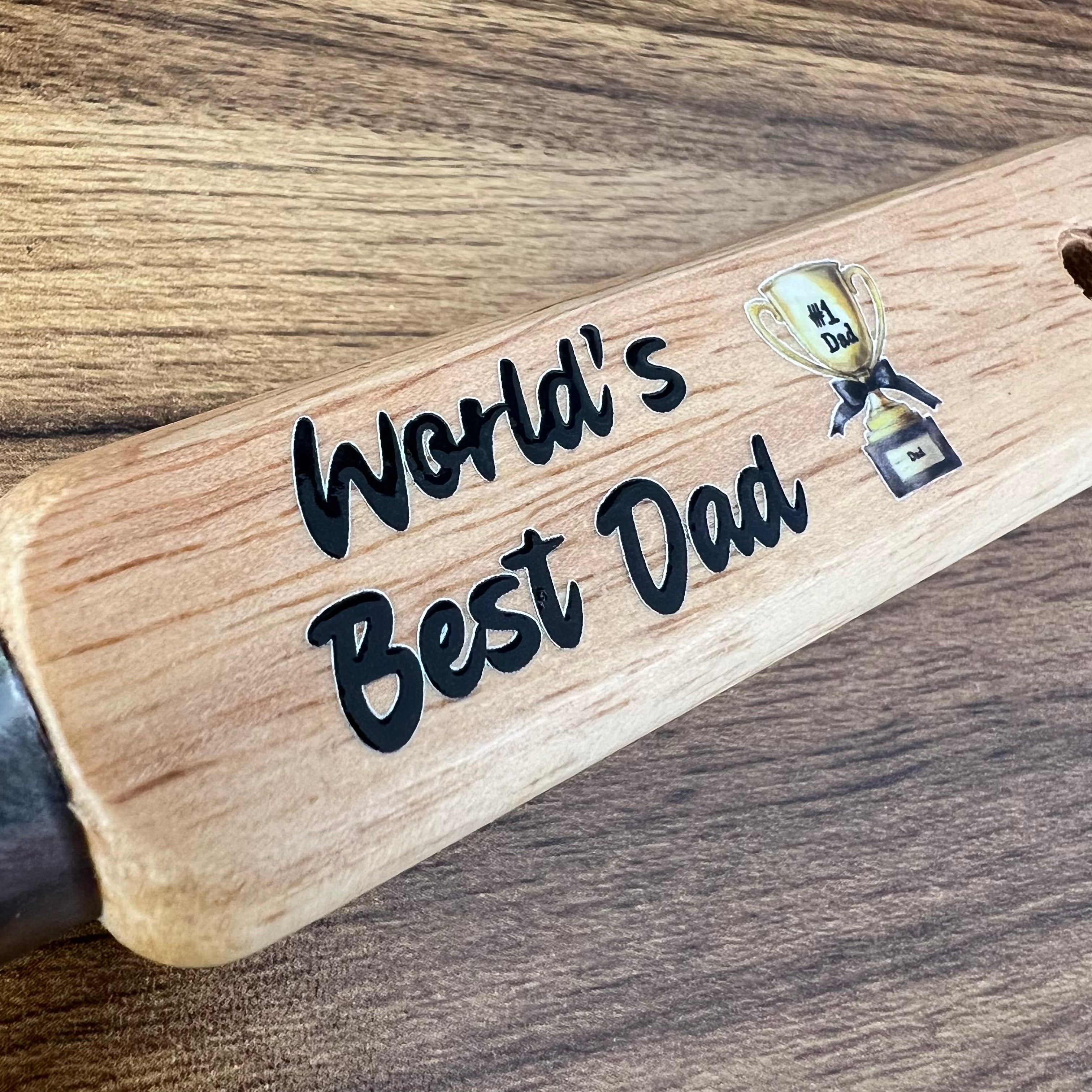 Wooden bottle opener with 'World's Best Dad' engraving on a wooden surface