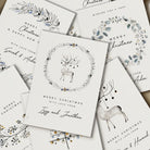 Collection of personalized Christmas cards with reindeer and floral designs.
