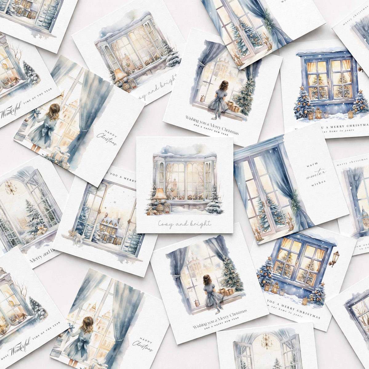 A scattered arrangement of small illustrated cards featuring watercolour-style Christmas window scenes in soft blue, cream, and gray tones, with handwritten and printed holiday text on a light background.