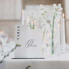 Table setting with a 'TABLE One' sign and floral arrangement at a weddingbreakfast