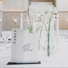 Elegant dining room setup with floral centerpieces and table numbers.