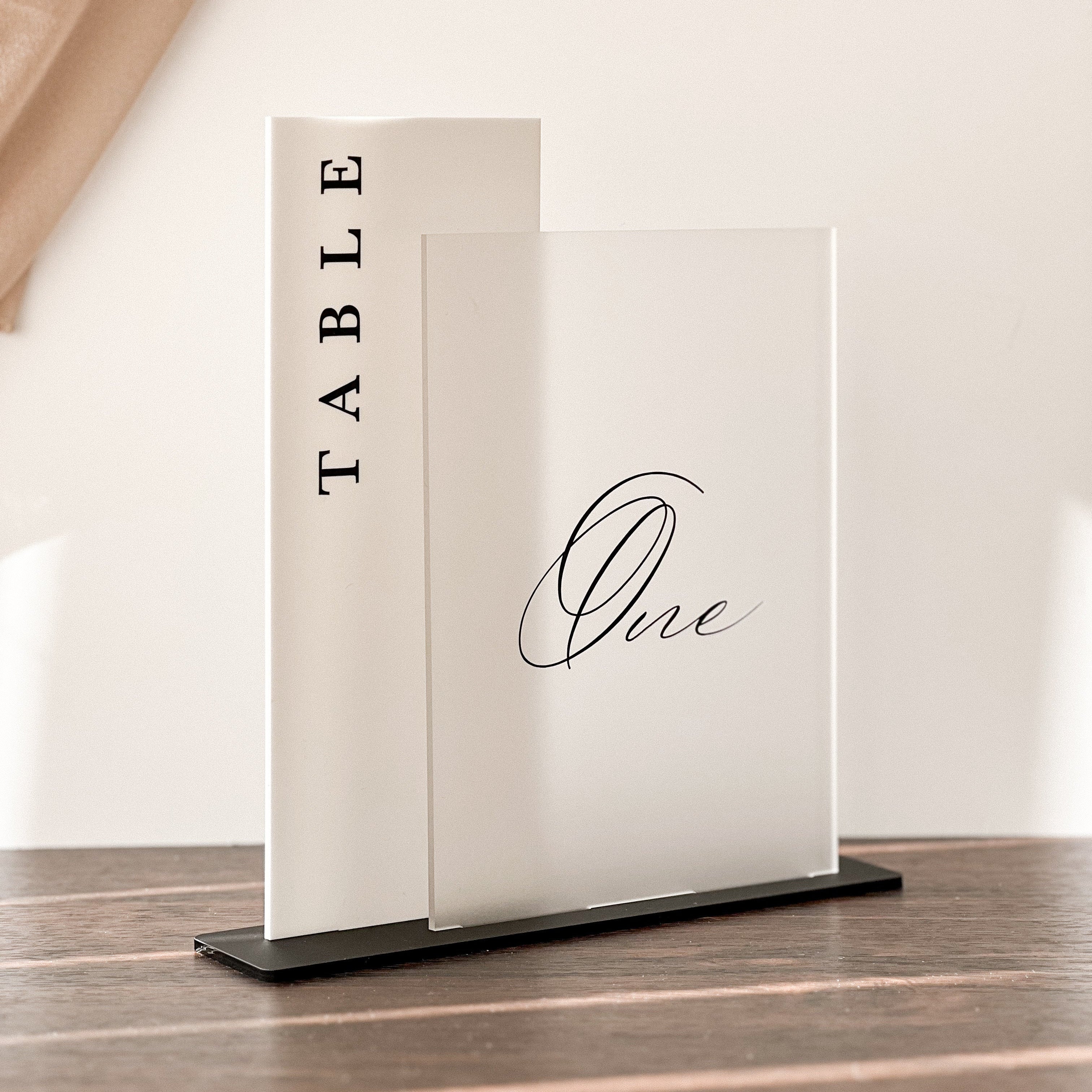 Table number sign with 'TABLE One' on a wooden floor