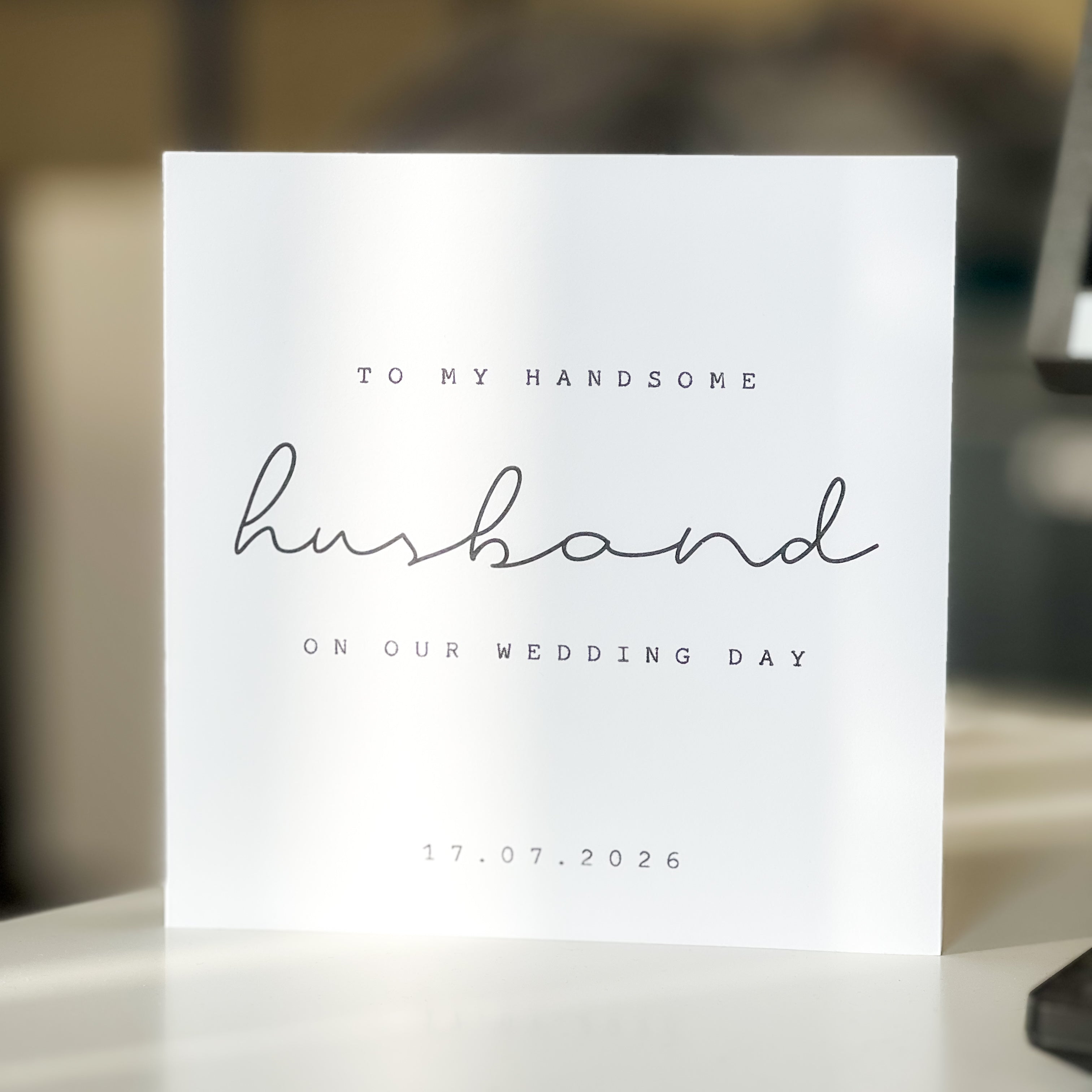 card reading to my handsome husband with a blurred background on white table.