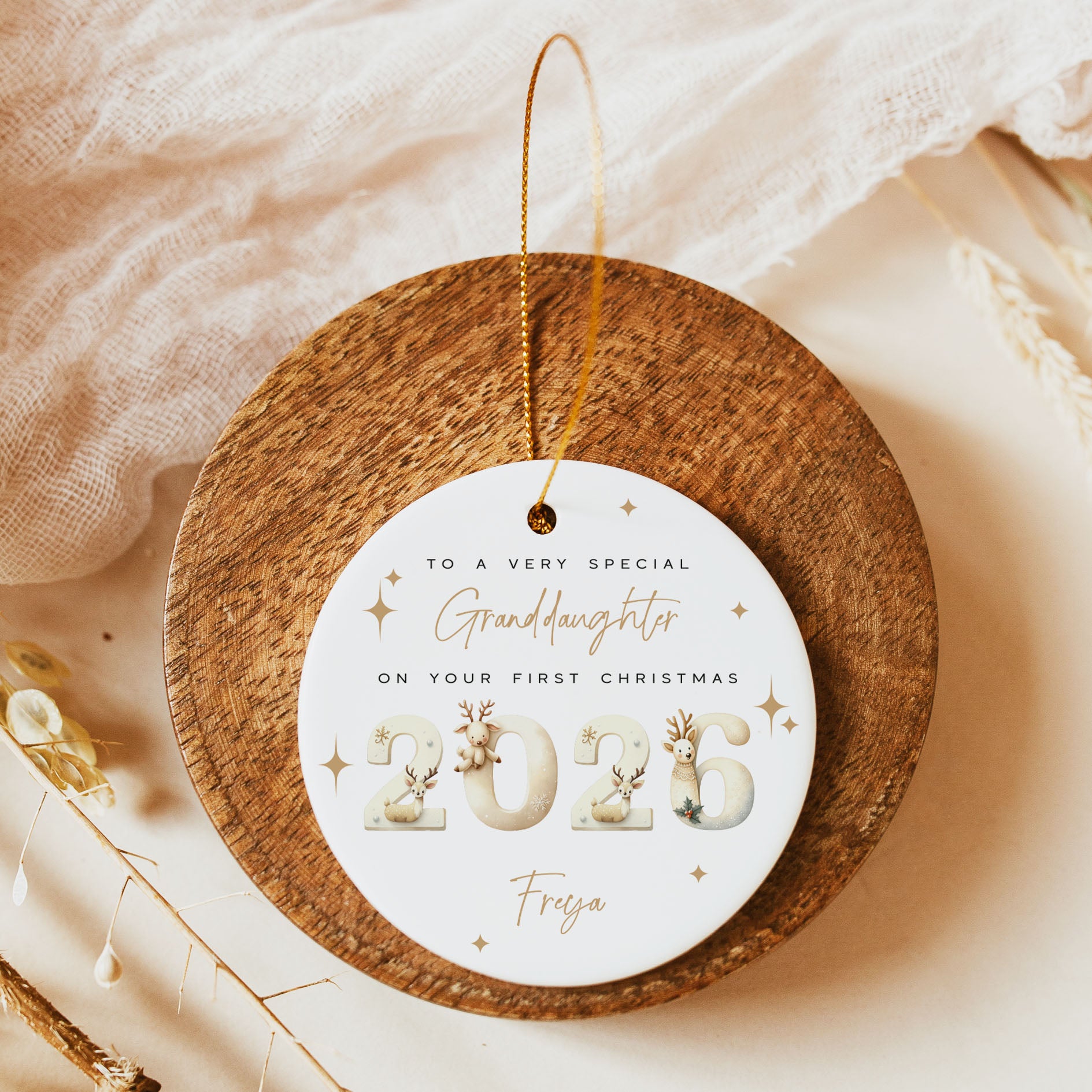 Ceramic christmas bauble with gold and black writing, and decorative watercolour "2026" year, with the name "Freya"