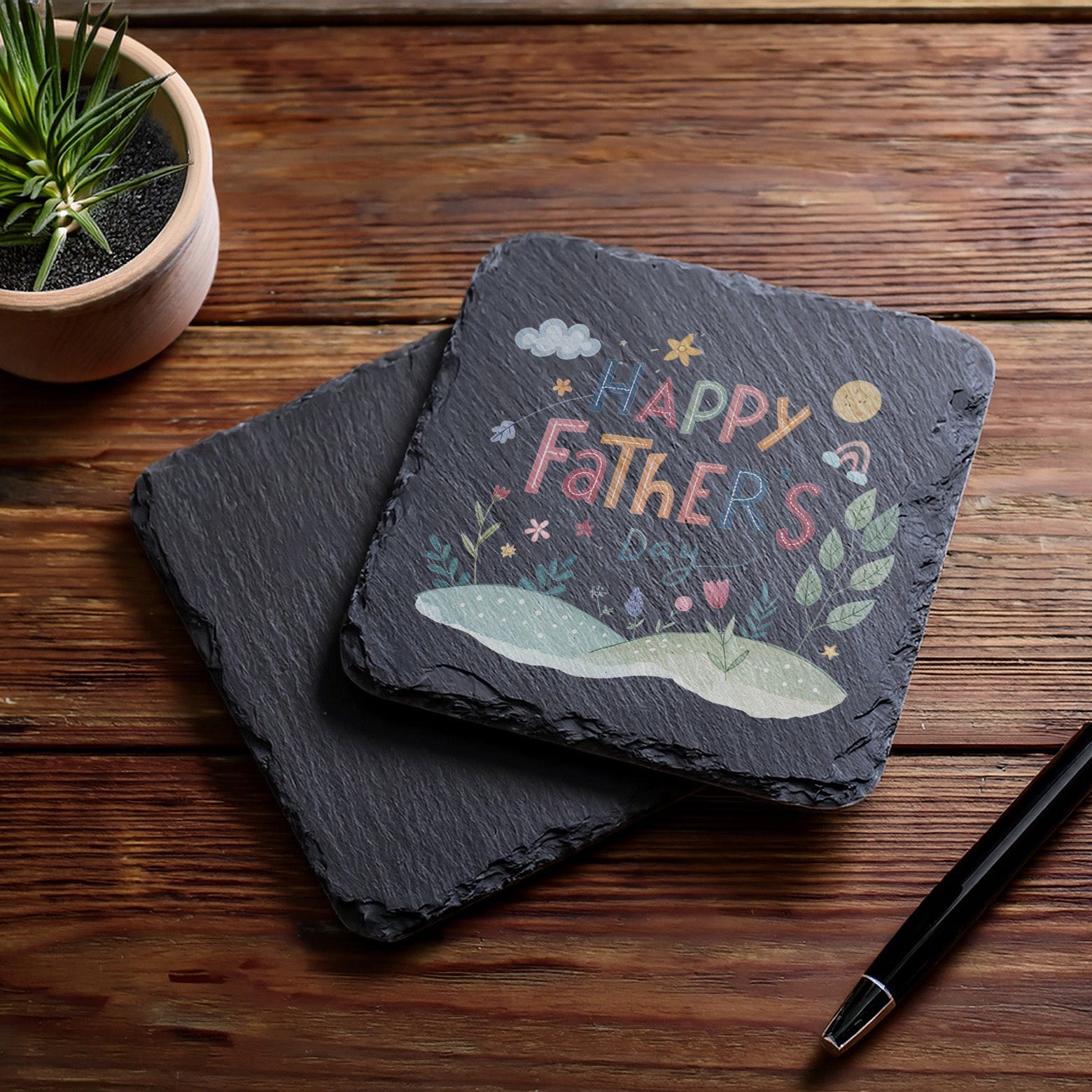 slate coaster with happy fathers day printed on it, on dark wood surface