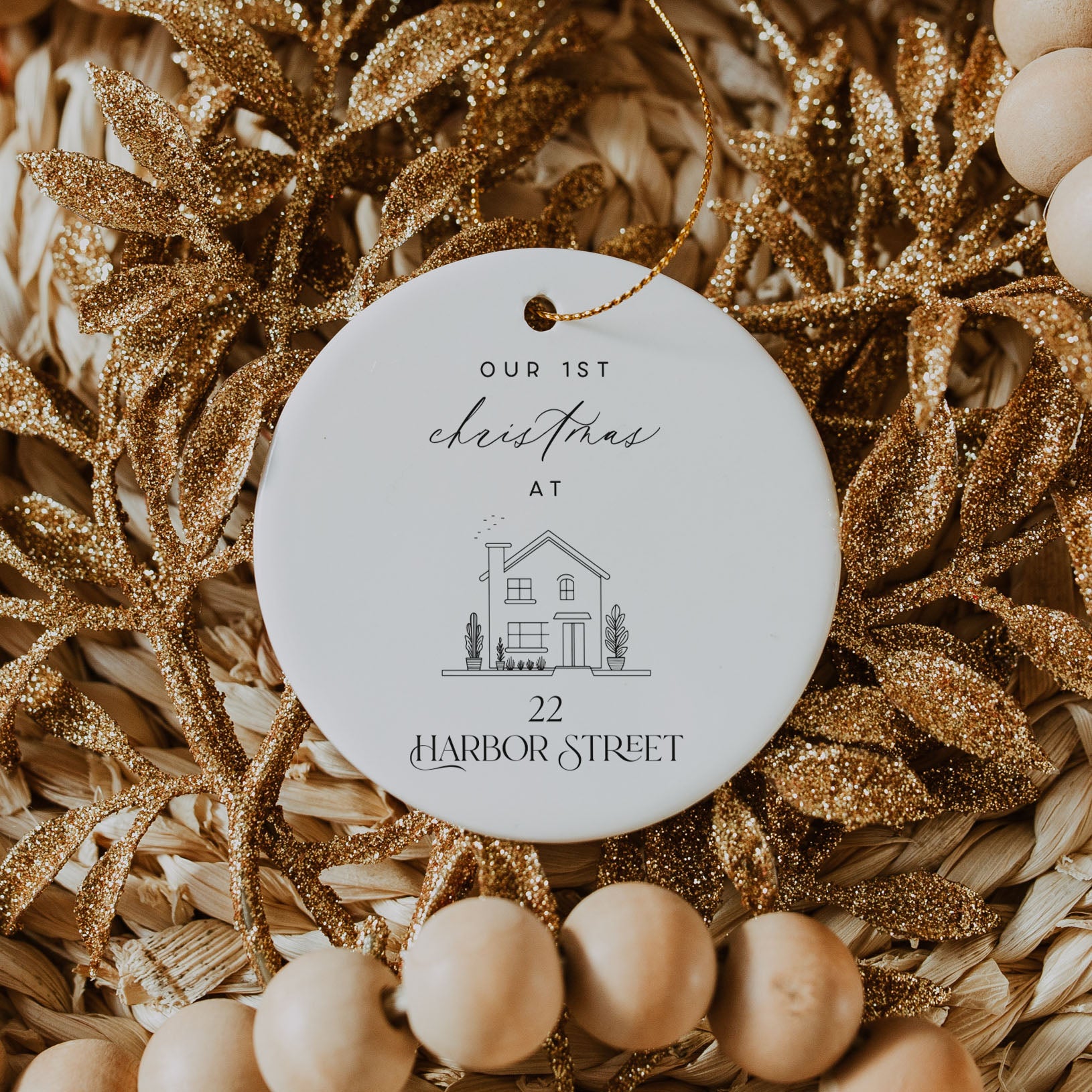 Decorative ornament with 'Our 1st Christmas at 22 Harbor Street' text on a gold leaf and bead background.