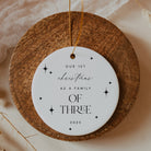 Round wooden ornament with a white tag featuring text on a neutral background