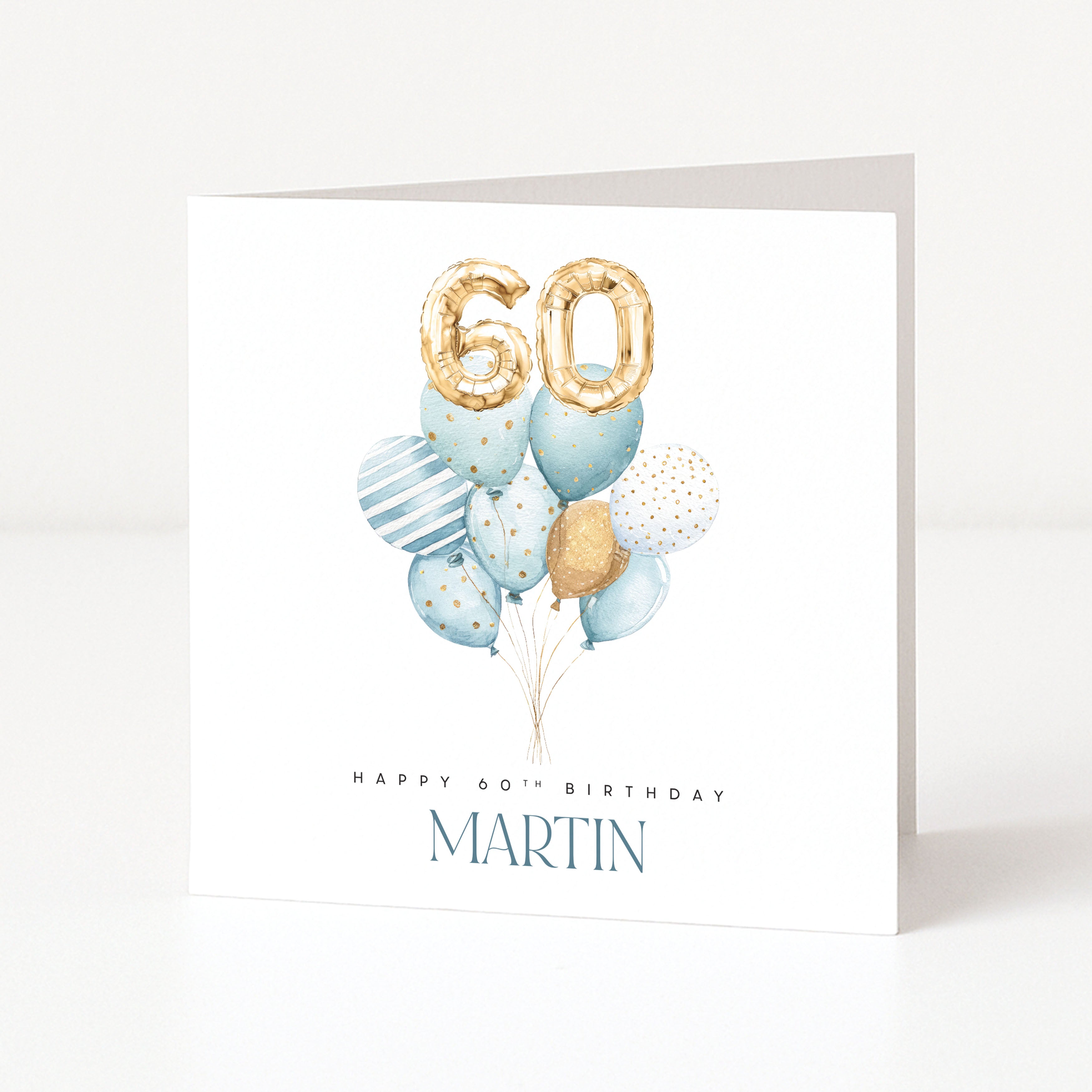 Personalised 60th birthday card with blue balloon cluster, gold number balloons and the name Martin.