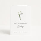 Greeting card with snowdrop flower illustration and birthday message on a white background
