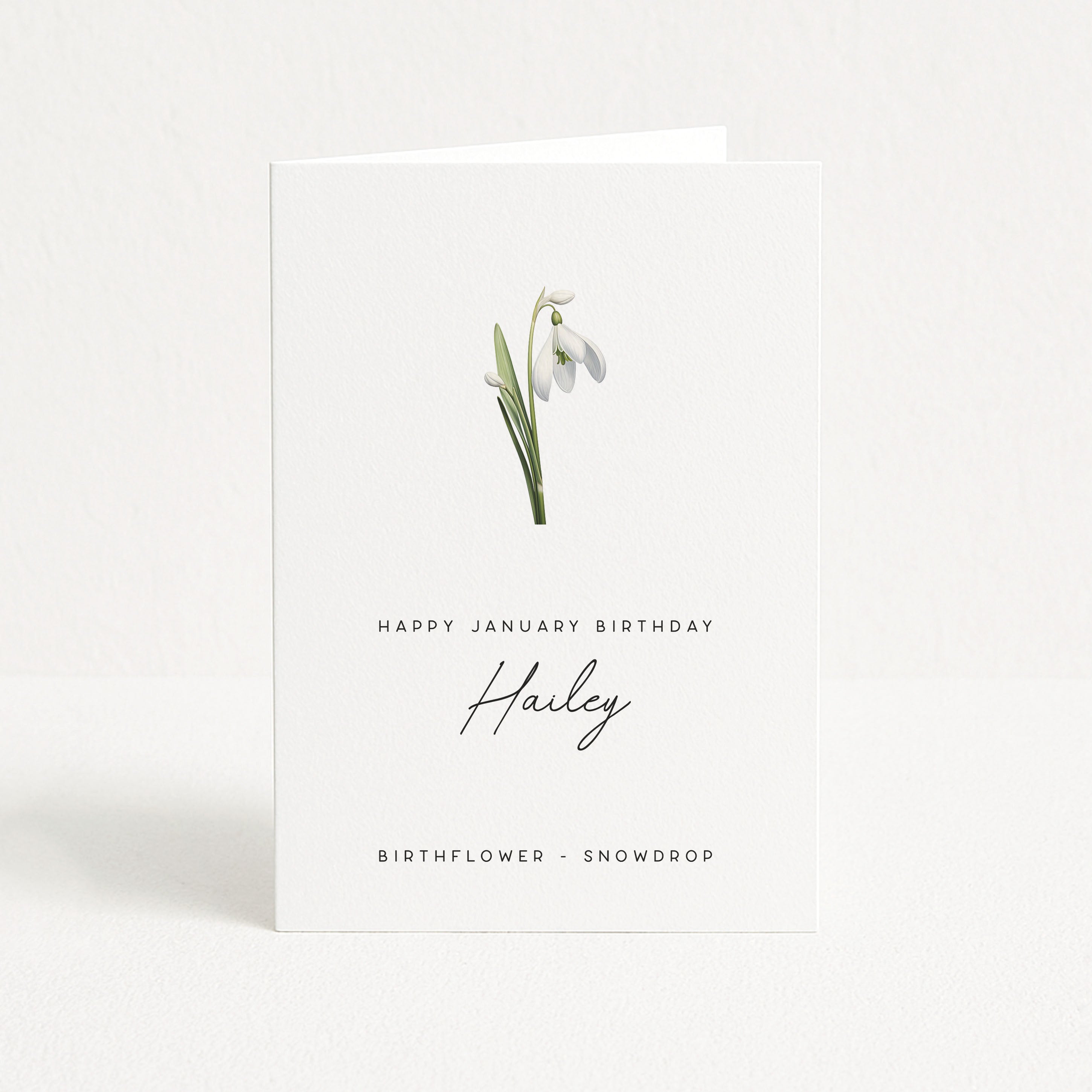 Greeting card with snowdrop flower illustration and birthday message on a white background