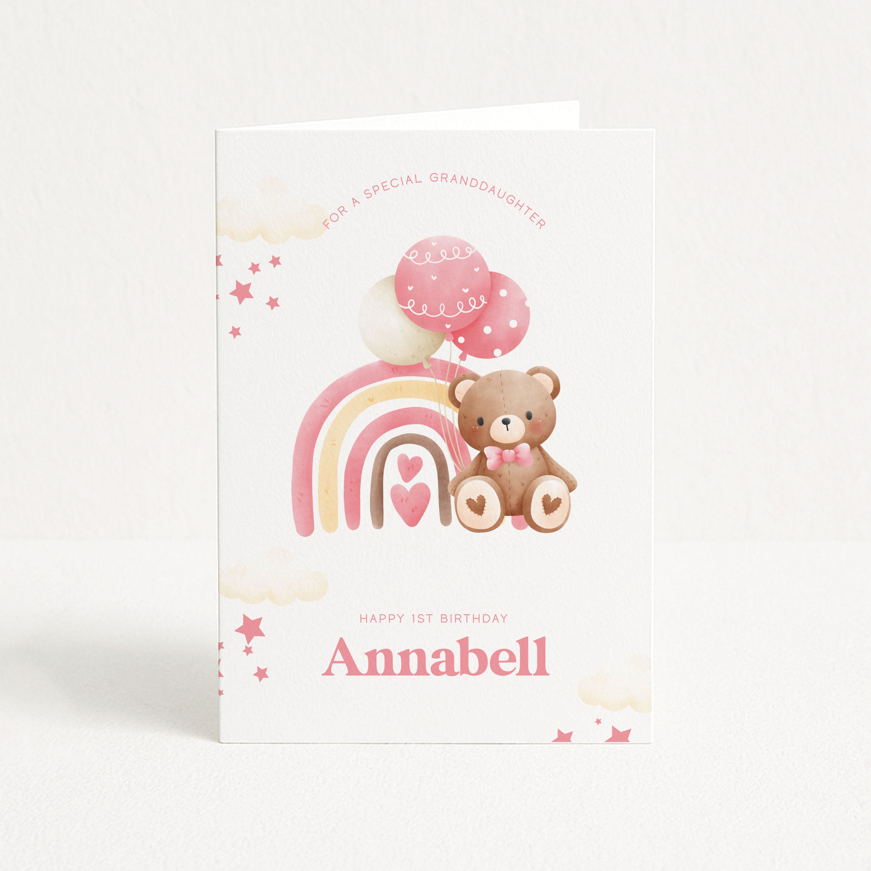 Birthday card with a teddy bear, rainbow, and balloons on a white background