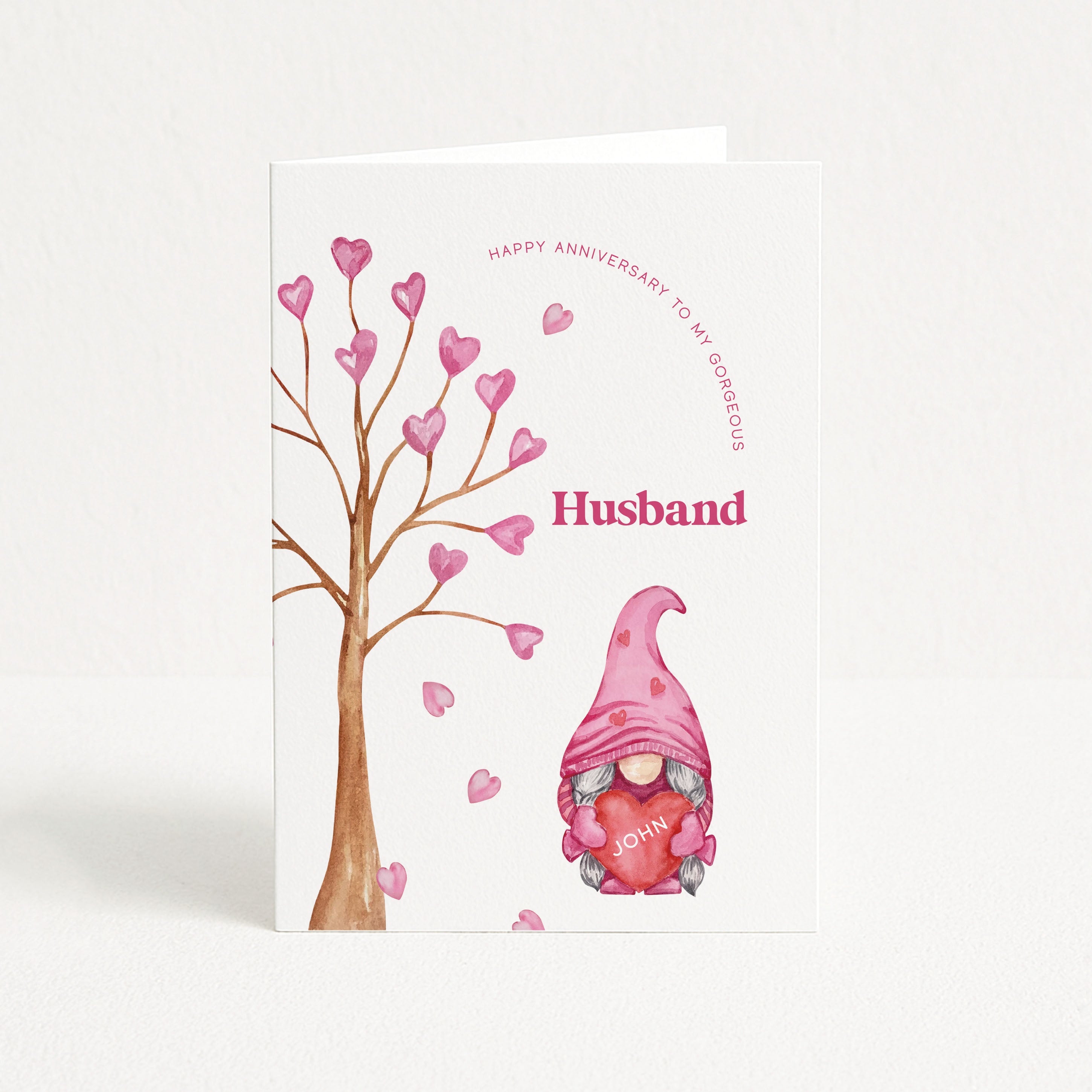 Greeting card with a gnome holding a heart and a tree with hearts, labeled 'Happy Anniversary to my gorgeous Husband'.