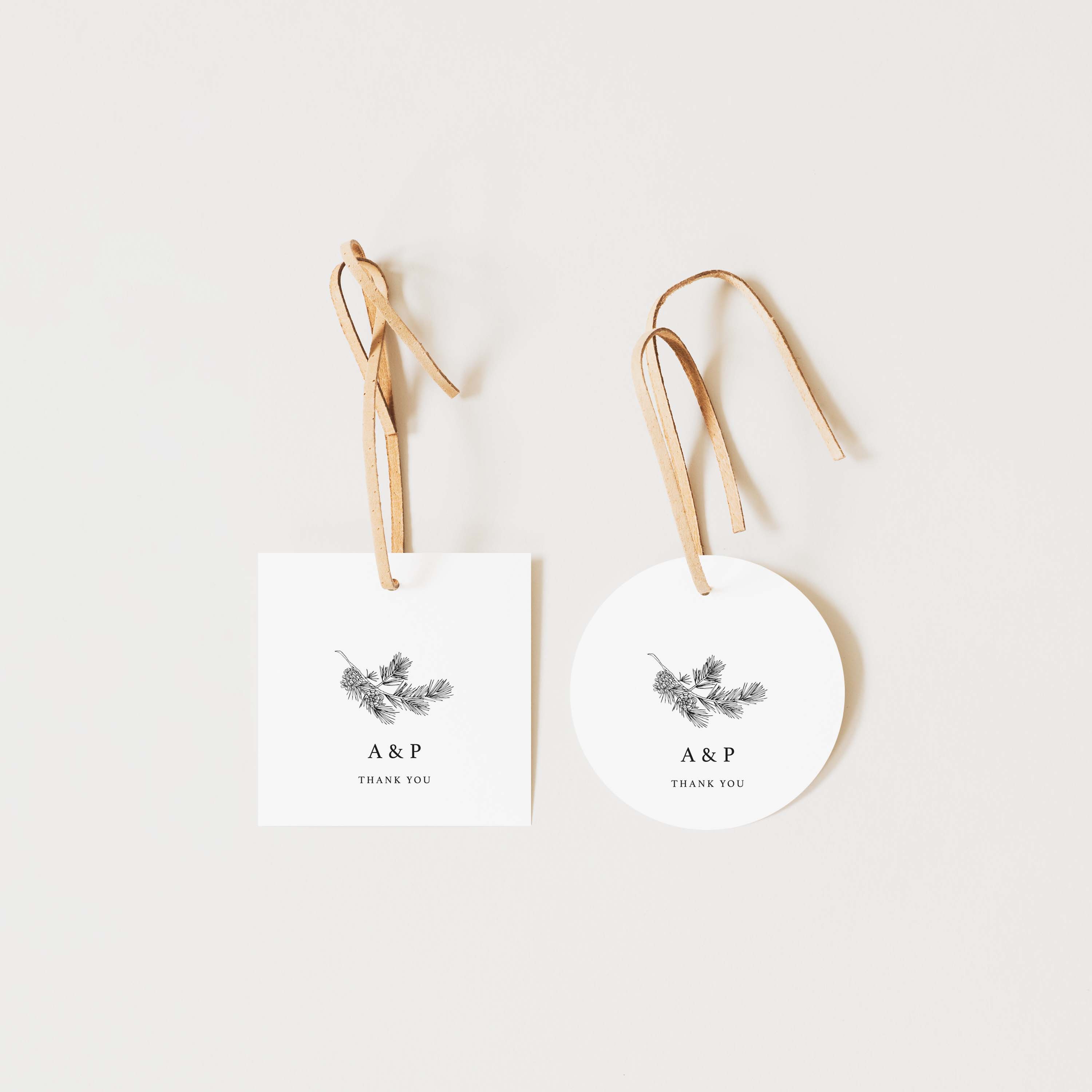 Two white tags with floral designs and 'A&P Thank You' text on a light beige background.