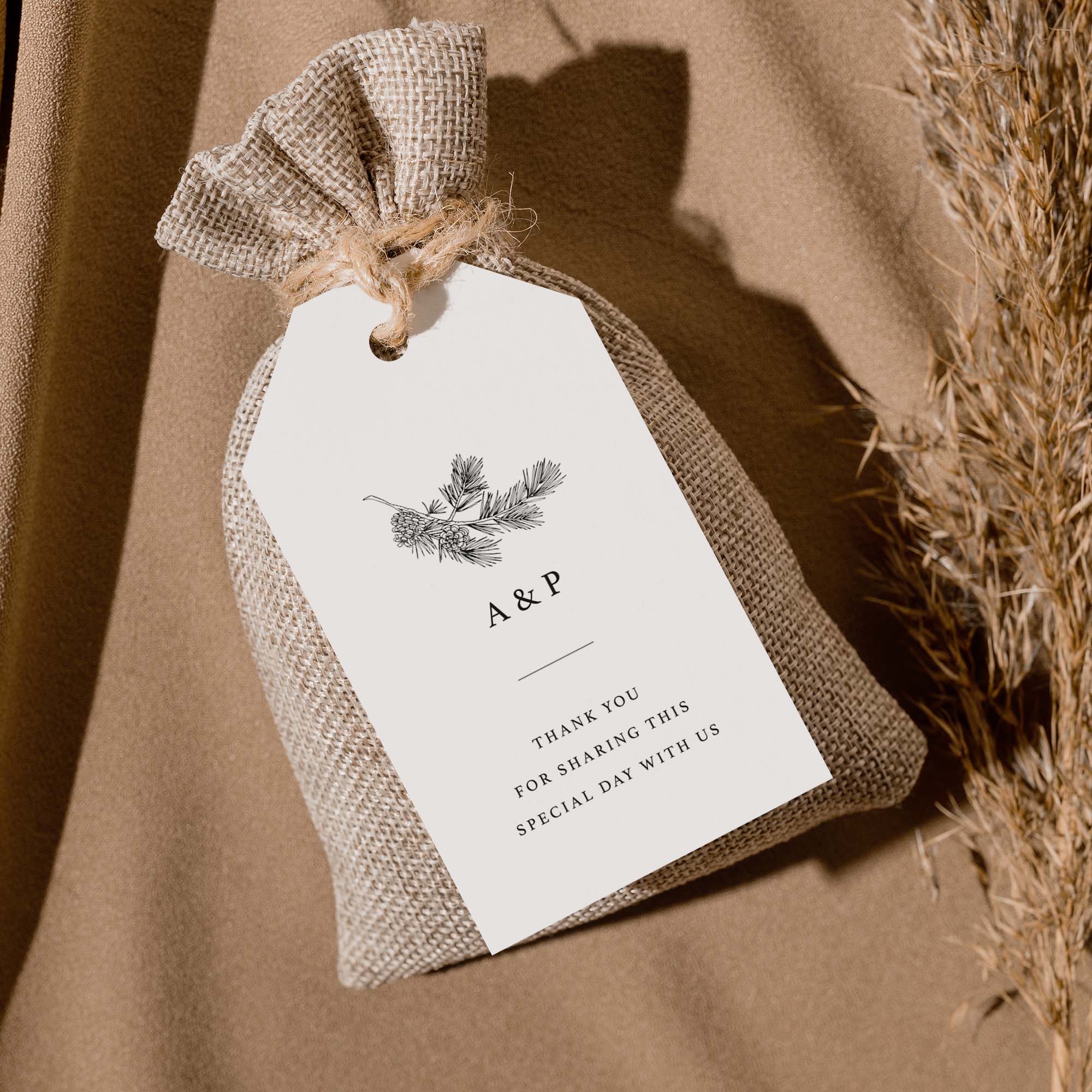 Burlap bag with a white tag featuring monogram and text on a brown background