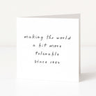 White card with black text 'making the world a bit more tolerable since 1984' on a white background