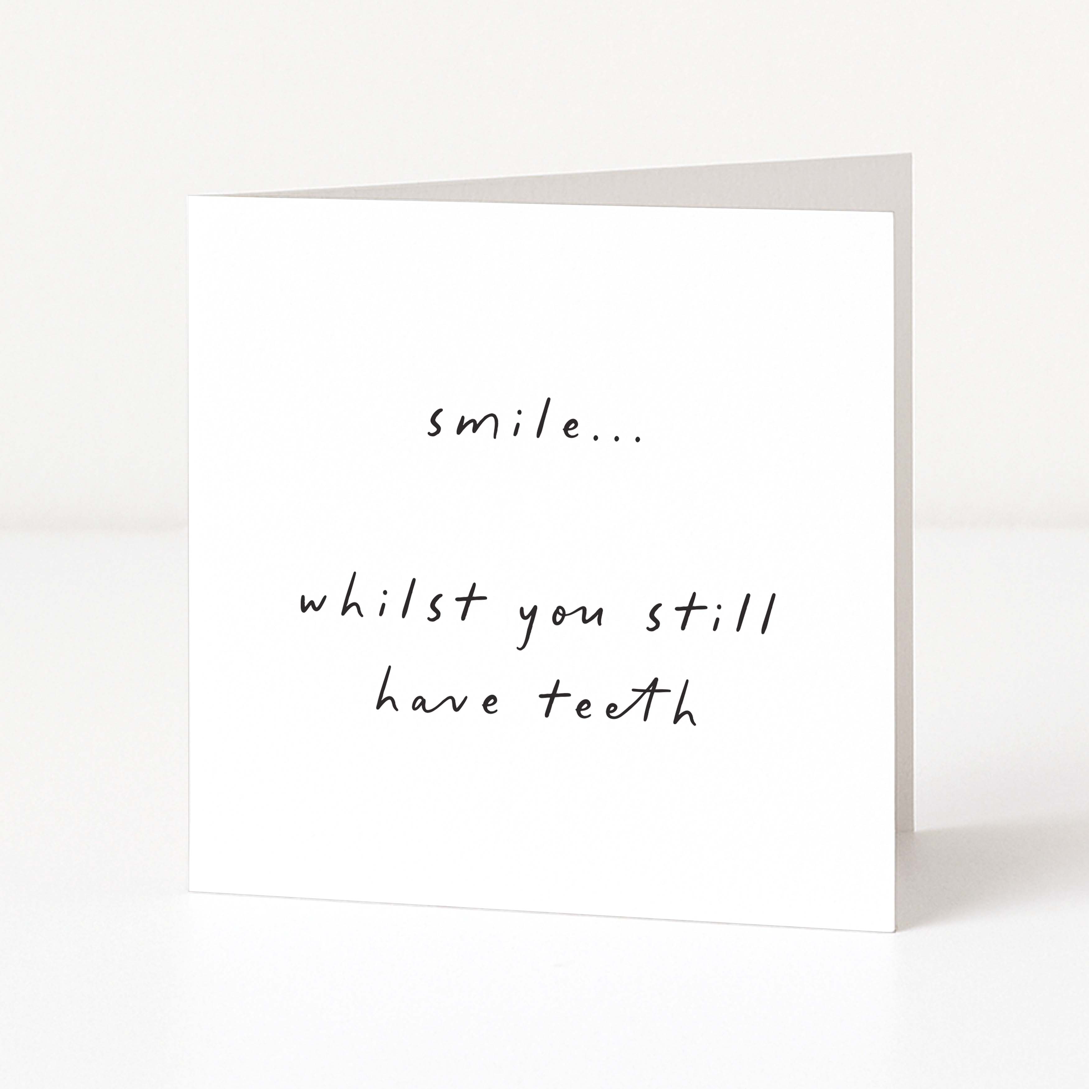 White card with black text 'smile... whilst you still have teeth' on a white background