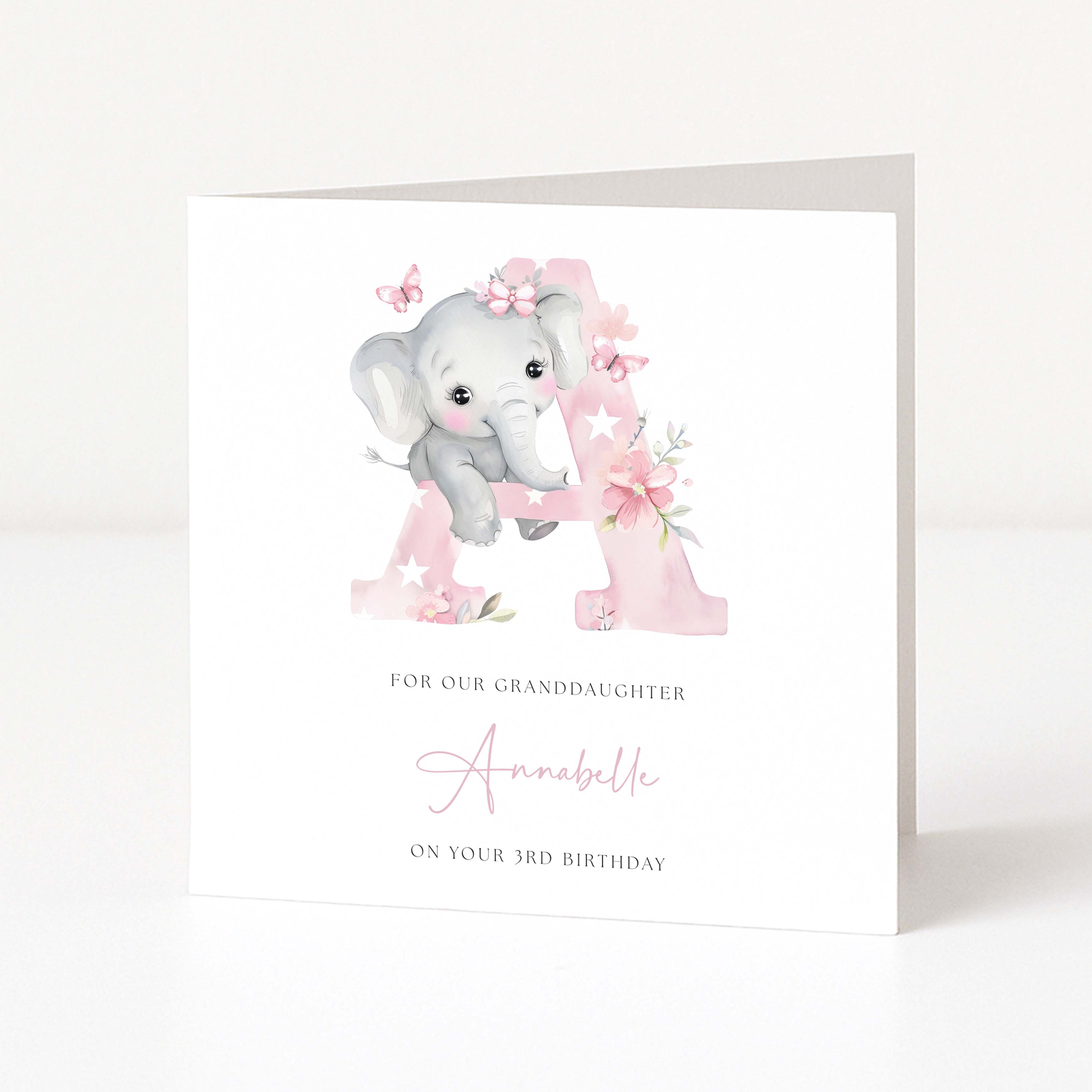 Greeting card with a cartoon elephant monogram and floral design on a white background