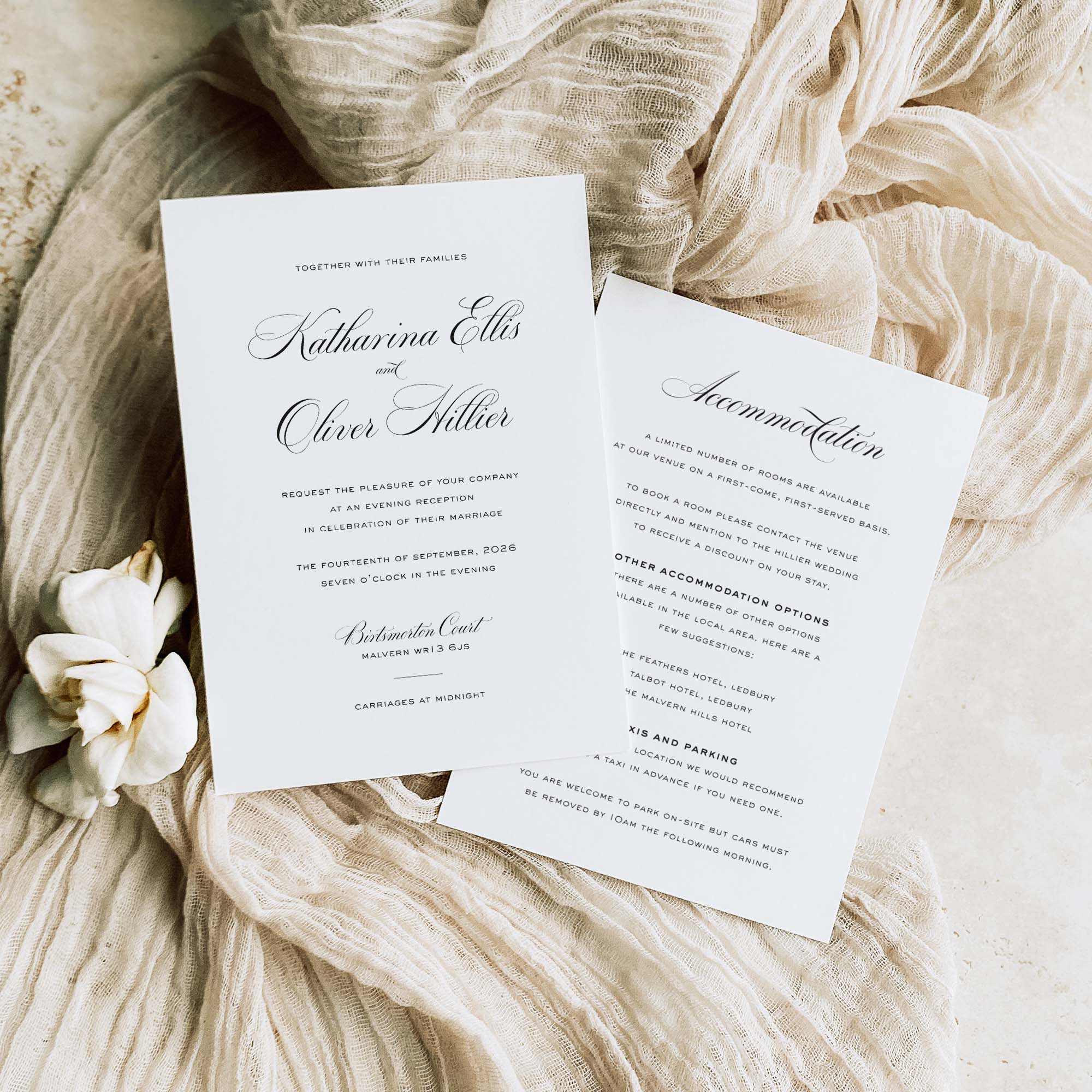 Wedding invitation card with accommodation details on a textured fabric background