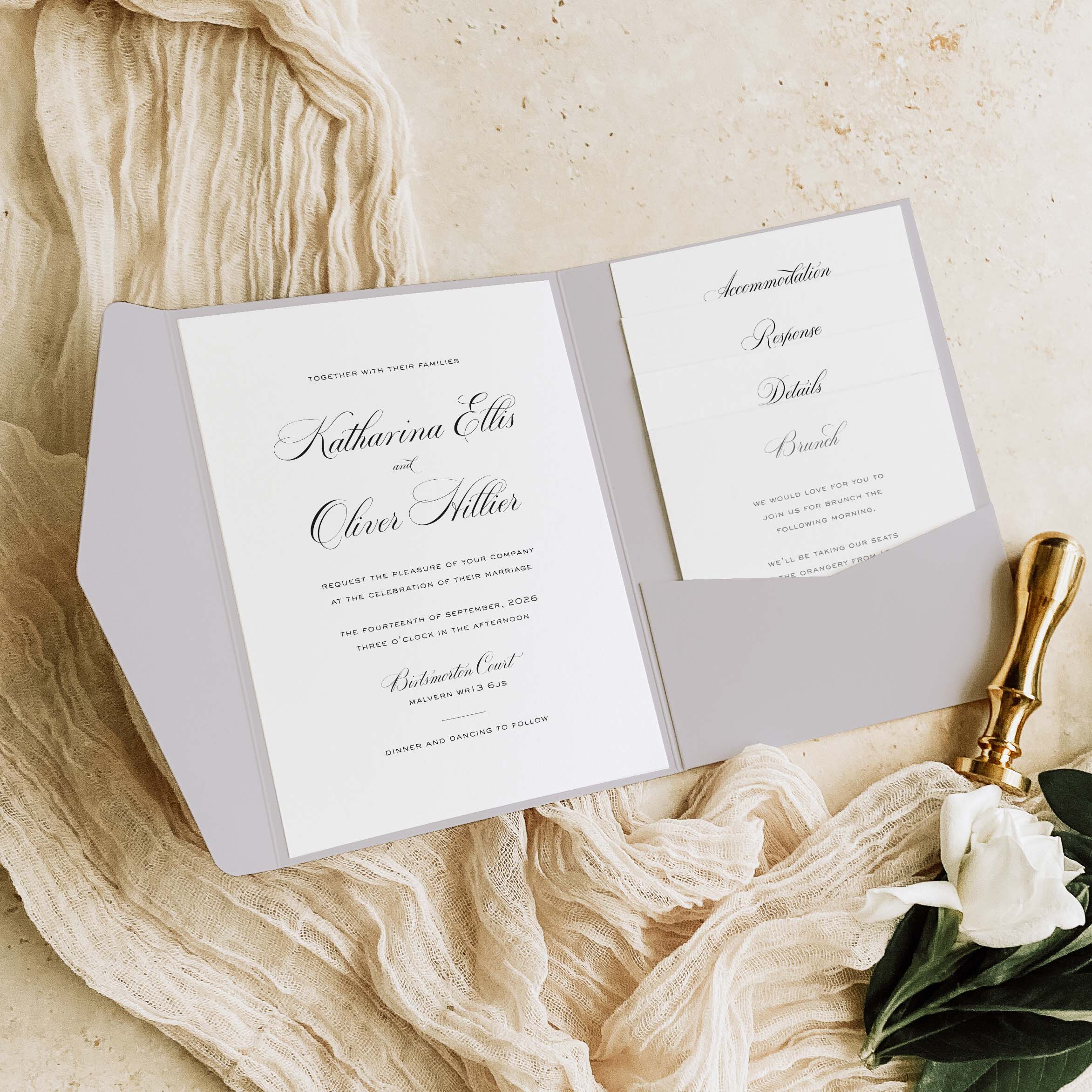 Wedding invitation card with gold seal on a textured beige surface