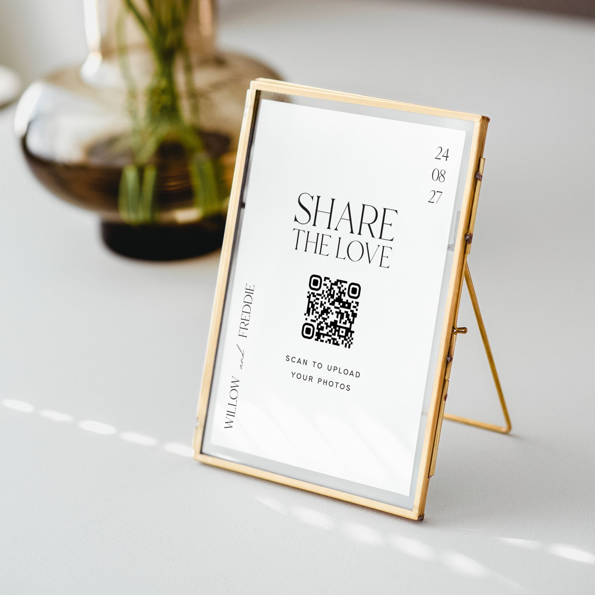 Gold-framed photo display with QR code on a white surface