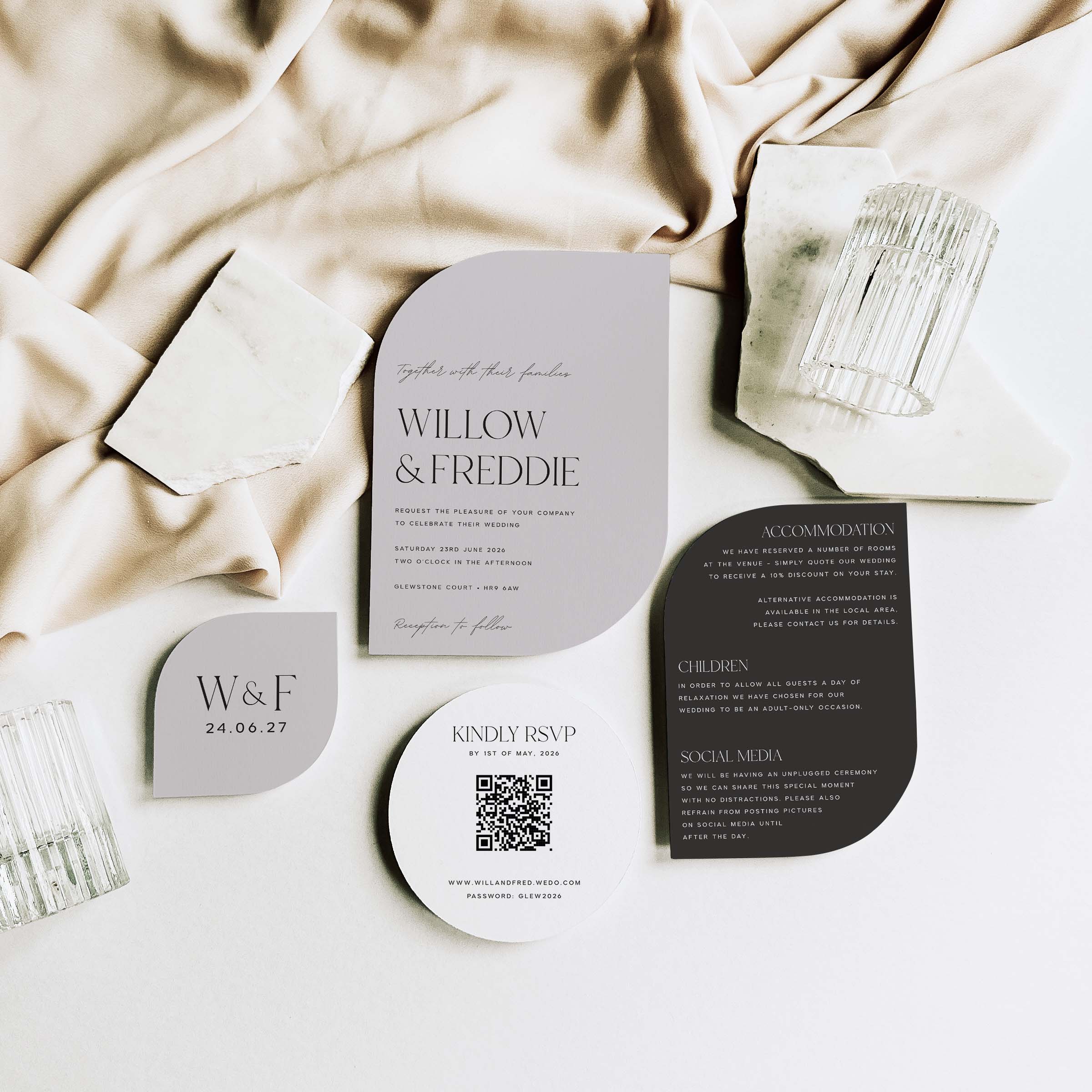 Wedding invitation set with RSVP card on a neutral fabric background