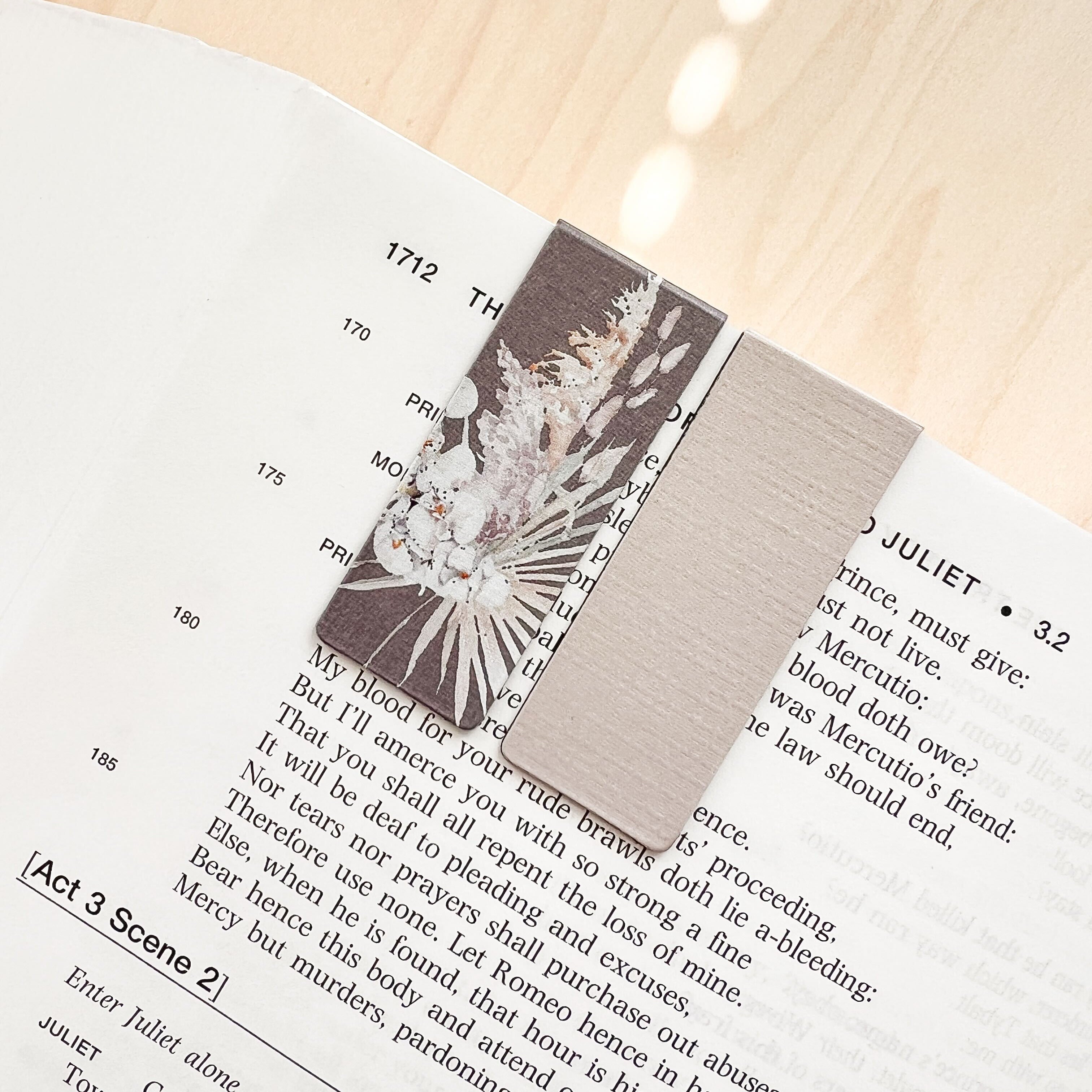 Open book with a decorative card on a wooden surface