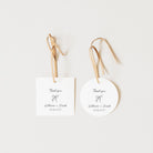 Two personalized wedding favor tags, one rectangular white card and one round white tag, both hanging from natural wood ribbons with printed 'Thank you' text and the names 'Katherine + Joseph' plus the date '03/06/2017'.