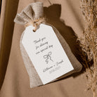 A personalized burlap drawstring gift bag with a white paper tag that reads 'Thank you for sharing our special day Katherine + Joseph 09.06.