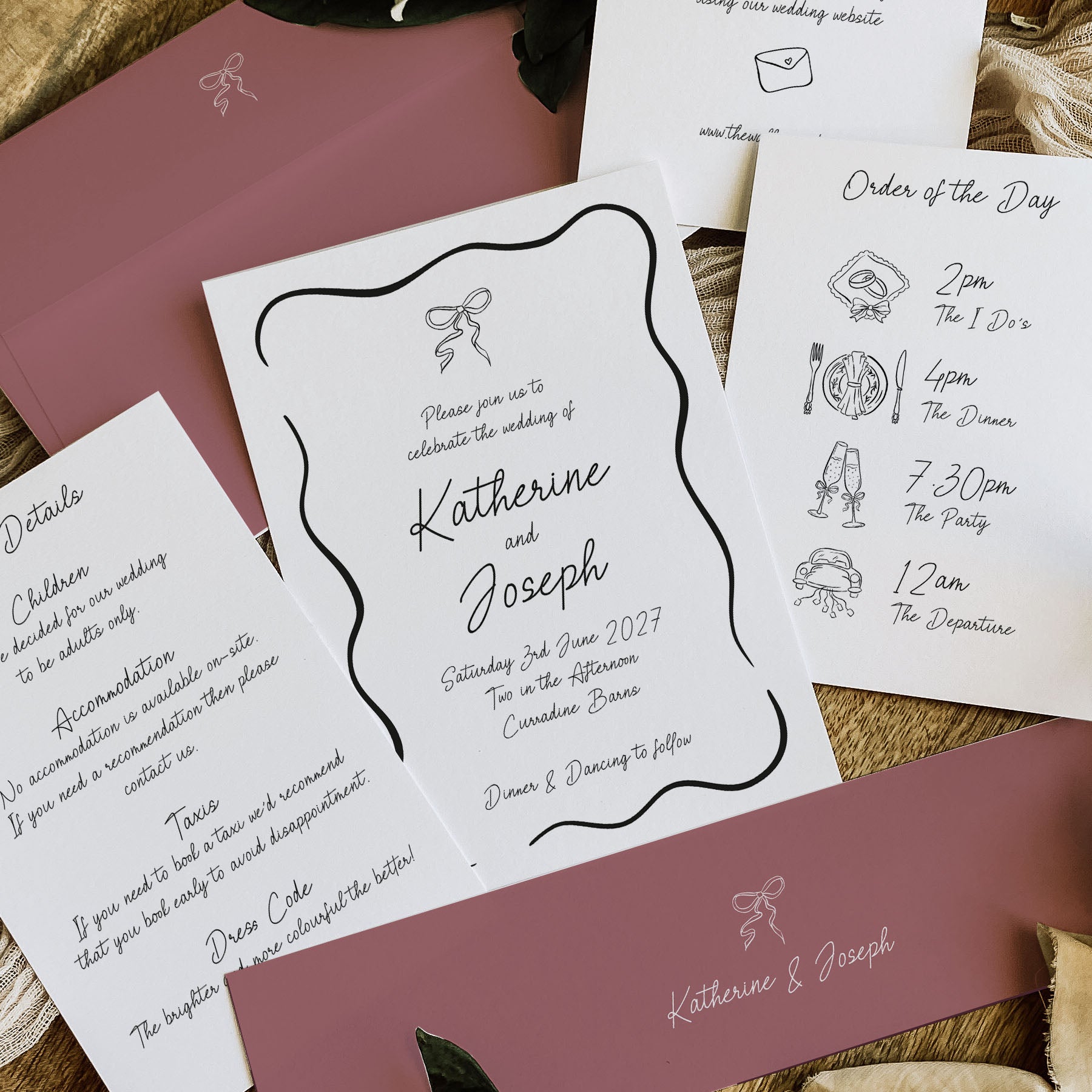 A styled flat-lay of wedding stationery including a white invitation card with black script text, an order of the day card, and matching dusty rose envelopes on a neutral surface.