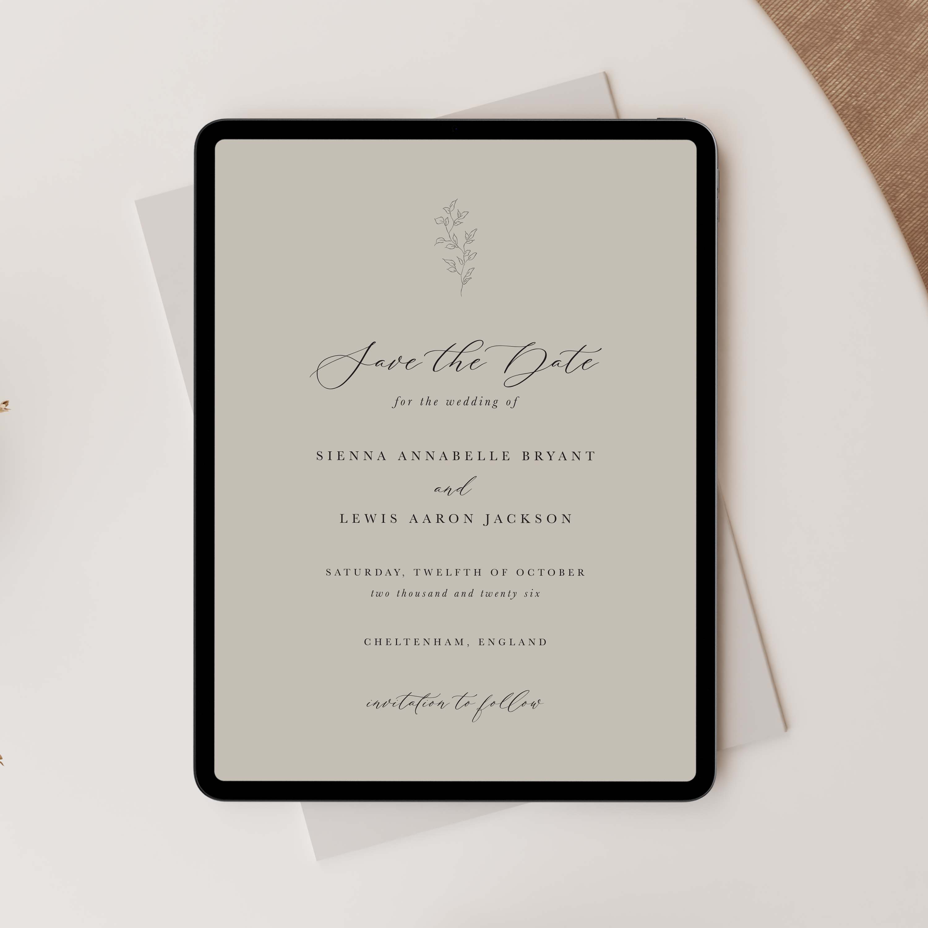 Wedding save the date card on a tablet with a beige background