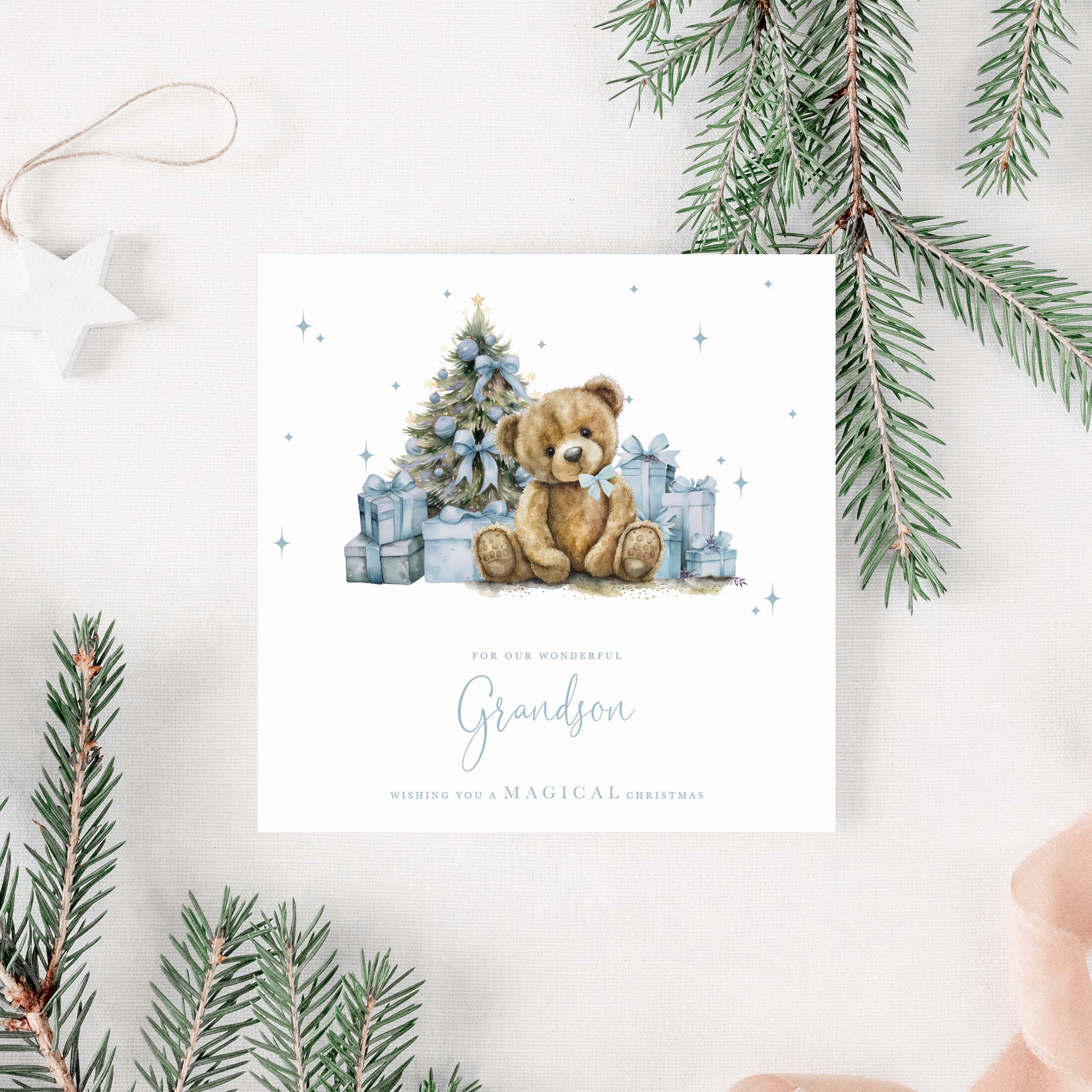 Christmas card for grandson with a teddy bear and tree surrounded by presents, framed by Christmas decorations.