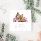 Christmas card for granddaughter with a teddy bear and tree surrounded by presents, surrounded by Christmas decorations.