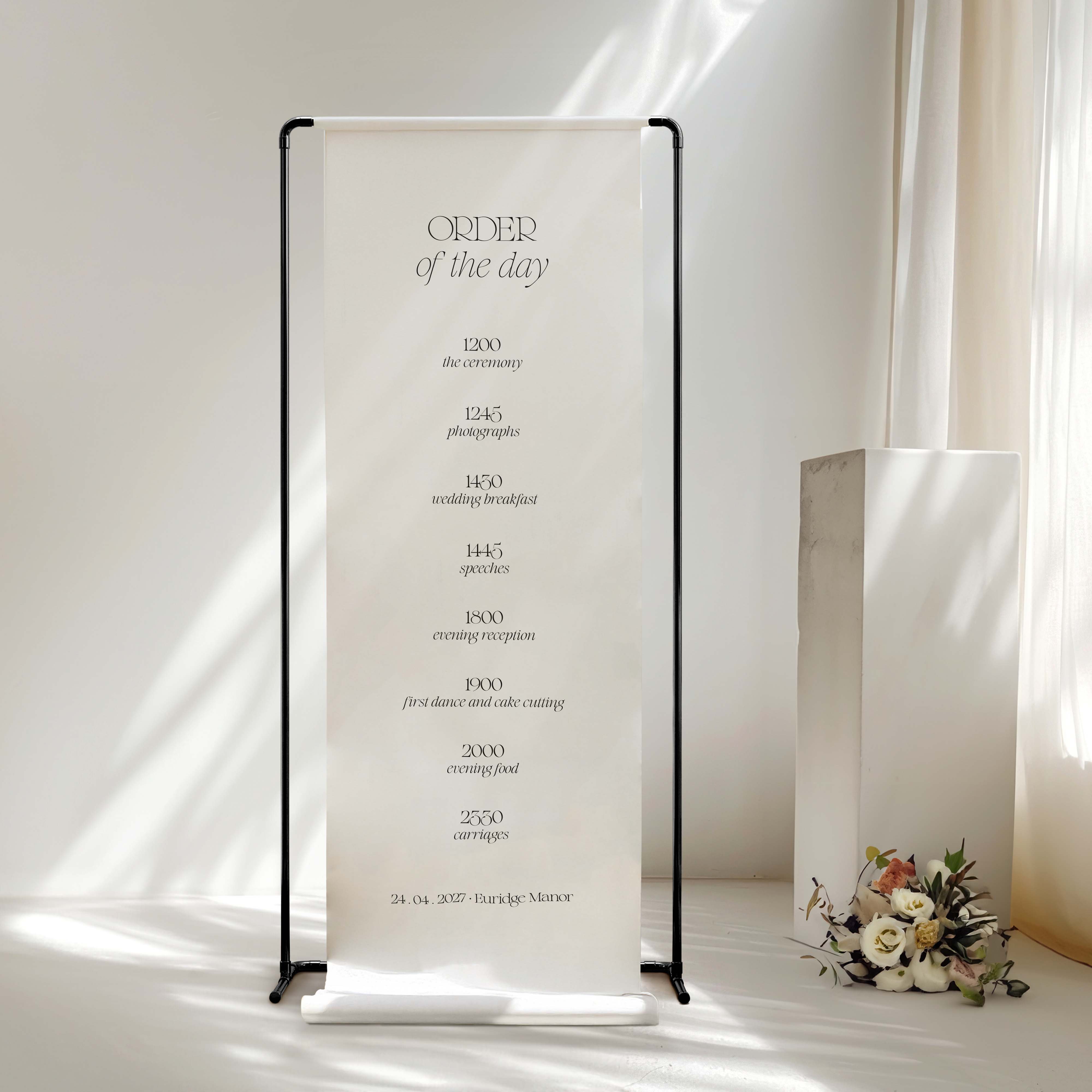 Wedding order of the day fabric sign with floral arrangement on a white background