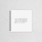 Spiral-bound wedding guestbook with 'Madeleine & Andrew' on a textured gray background