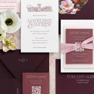 Collection of letterpress wedding invitations with floral elements and stationery items.
