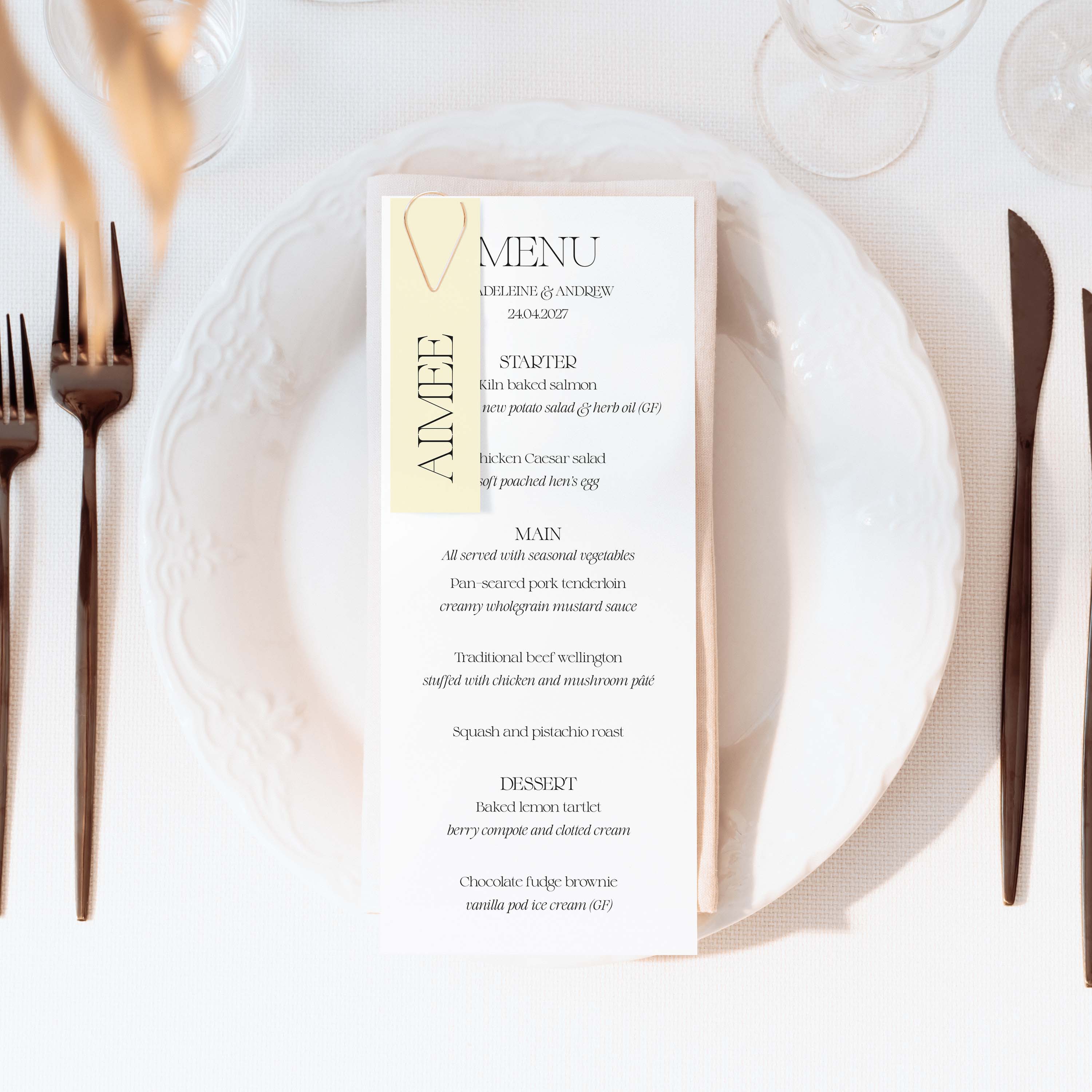 Menu card on a white plate with cutlery