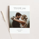 Wedding thank you card with a couple embracing and flowers on a light background