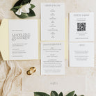Wedding invitation set with RSVP card and order of the day on a wooden surface.